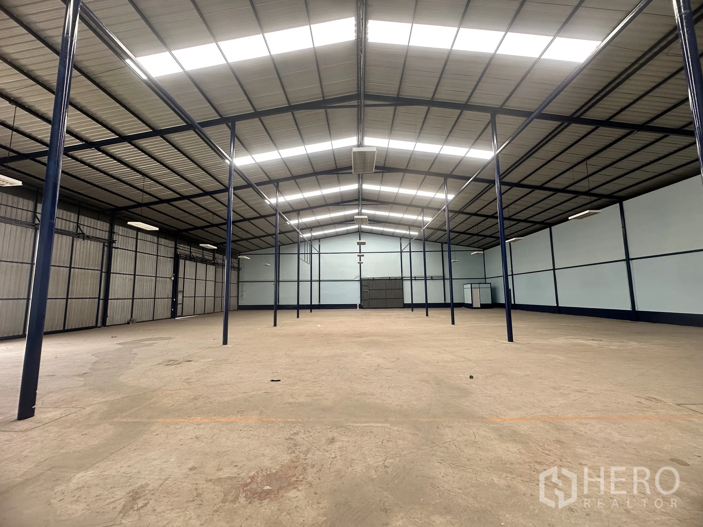 仓库 for rent in Lat Krabang, Bangkok - 宽敞库房，钢柱排布整齐，顶部照明充足，侧墙为金属门板。