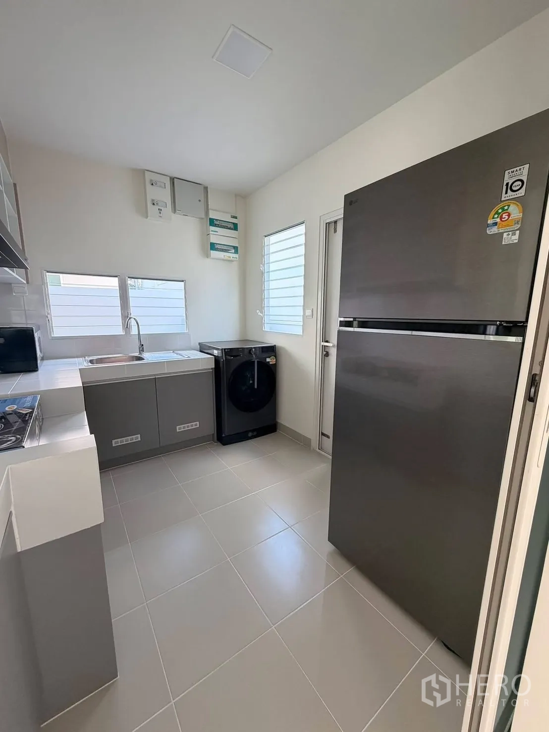 Detached House for rent in Bang Phli, Samut Prakan - Kitchen view showing refrigerator, washer and ample counter space.