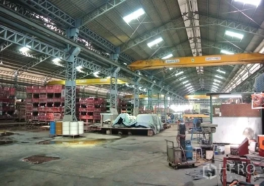 โรงงาน ขายในBang Phli, Samut Prakan - ทางเดินเวิร์กชอปพร้อมชั้นวางของและเครนคานวิ่งสีเหลือง.