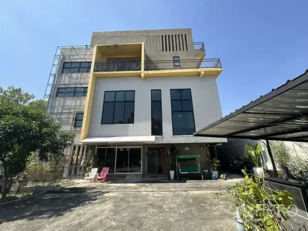 Home Office for sale in Lam Luk Ka, Pathum Thani - Multi-storey home office facade with tall windows, balcony and covered carport in Lam Luk Ka under a clear sky