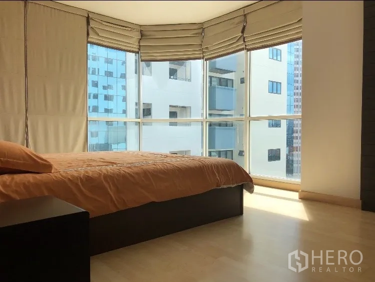 公寓 出租在Watthana, Bangkok - 转角卧室，落地窗、罗马帘与浅色木地板。