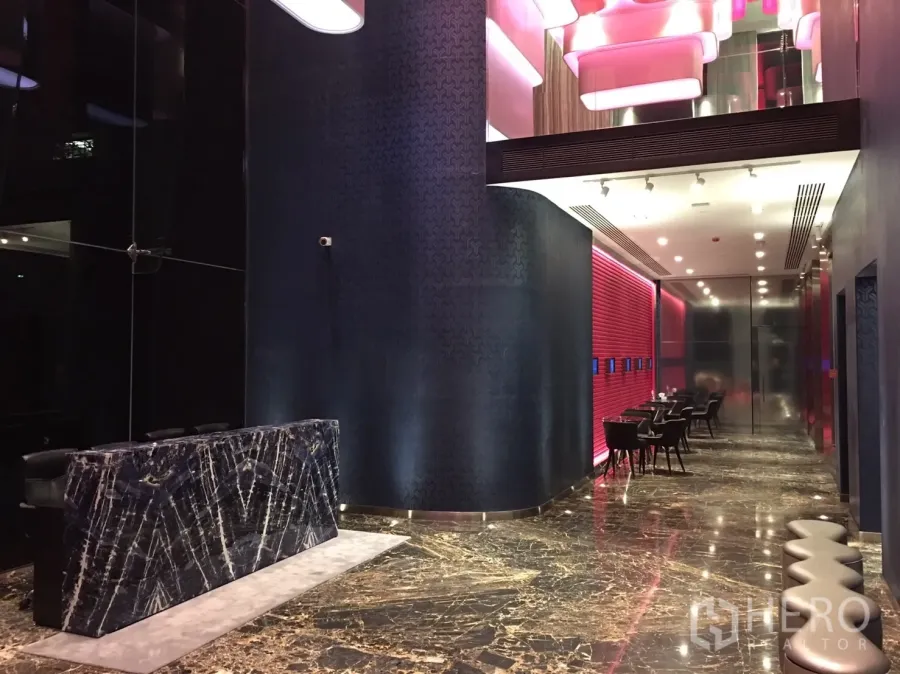 คอนโด ให้เช่าในWatthana, Bangkok - ล็อบบี้คอนโดสไตล์โมเดิร์น พื้นหินอ่อน เคาน์เตอร์หินสีเข้ม ไฟฝ้าเพดานสีชมพูและที่นั่งรับรอง