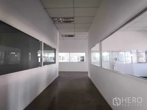 货栈 出租或出售在Pathum Thani - 内部走廊，设有观景窗可查看生产或仓储区。