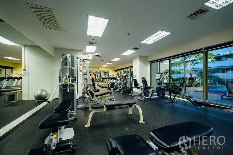 Condominium for rent in Watthana, Bangkok - Weights area in gym with benches and strength equipment.
