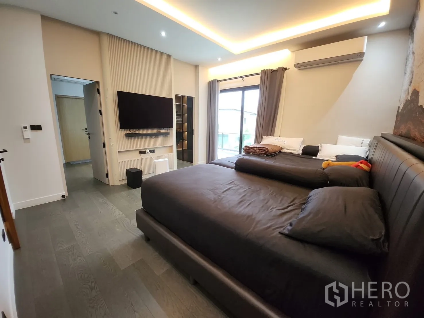 Detached House for rent in Bang Phli, Samut Prakan - Cozy bedroom with wall-mounted TV, feature wall and balcony door.