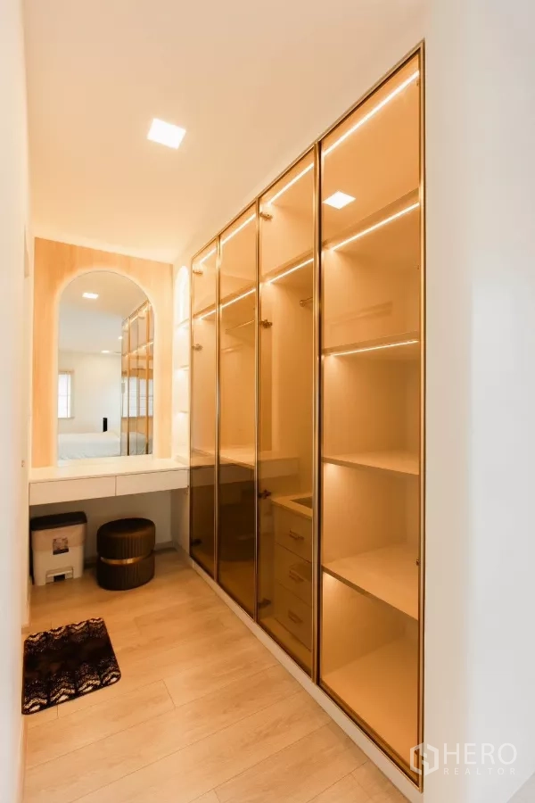 独立式住宅 出租或出售在Bang Phli, Samut Prakan - 步入式衣帽间，玻璃柜门与拱形镜台。
