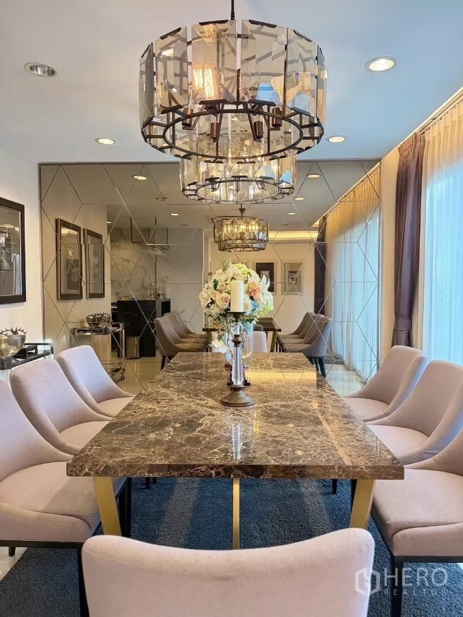 Detached House for rent or sale in Prawet, Bangkok - Elegant dining room with marble table, upholstered chairs and crystal chandeliers.