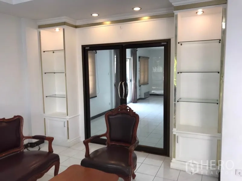 บ้าน ให้เช่าในPhra Khanong, Bangkok - โถงนั่งเล่นมีตู้โชว์กระจกบิวท์อินและประตูบานเลื่อนกรอบดำ