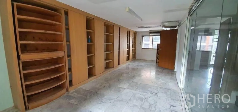 Home Office for rent in Watthana, Bangkok - Long office area featuring wooden built-in shelves and windows.