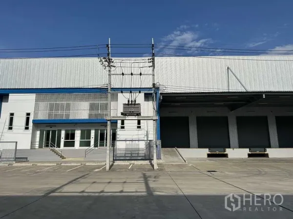 工厂 出租在Bang Sao Thong, Samut Prakan - 正立面展示办公楼、变压器及多组高位装卸卷帘门