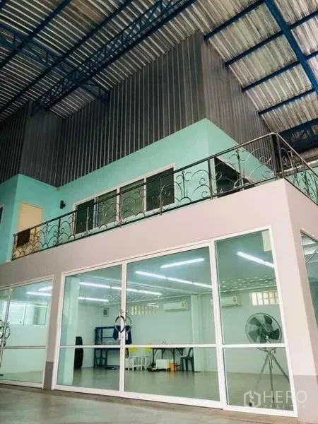 Warehouse for rent in Nakhon Pathom - Warehouse interior with high steel roof, mezzanine office and glass-walled workspace in Nakhon Pathom.