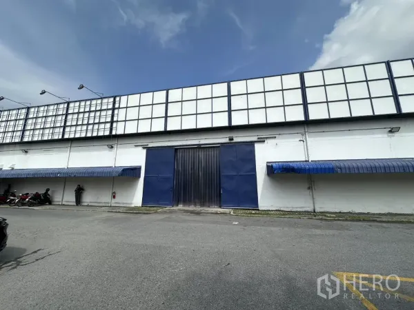 คลังสินค้า ให้เช่าในPhra Khanong, Bangkok - ด้านหน้าโกดัง ประตูโหลดสีน้ำเงิน ผนังสีขาว พร้อมกันสาดสีน้ำเงิน ในย่านพระโขนง