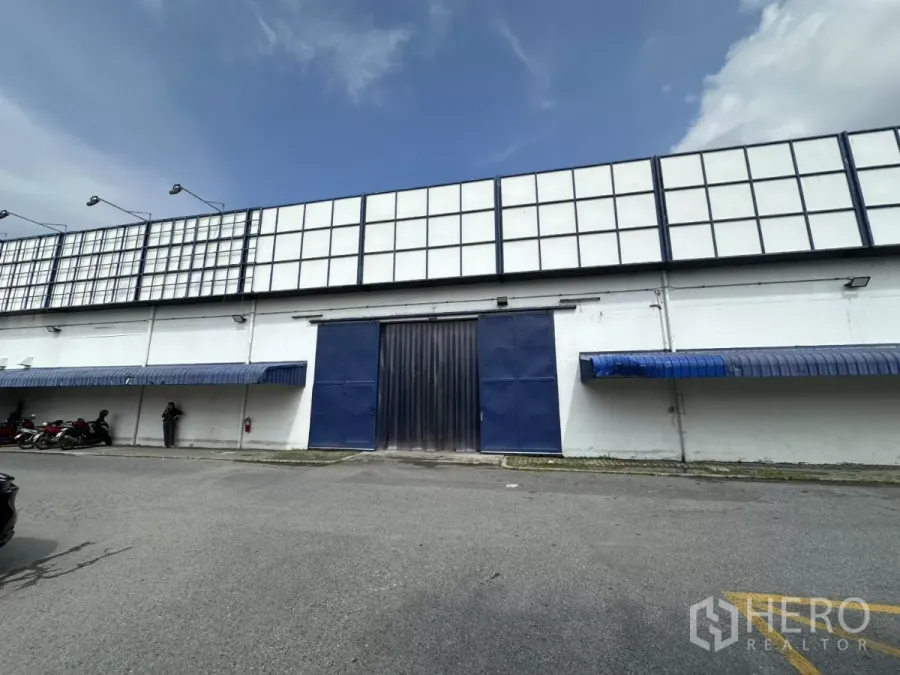 คลังสินค้า ให้เช่าในPhra Khanong, Bangkok - ด้านหน้าโกดัง ประตูโหลดสีน้ำเงิน ผนังสีขาว พร้อมกันสาดสีน้ำเงิน ในย่านพระโขนง
