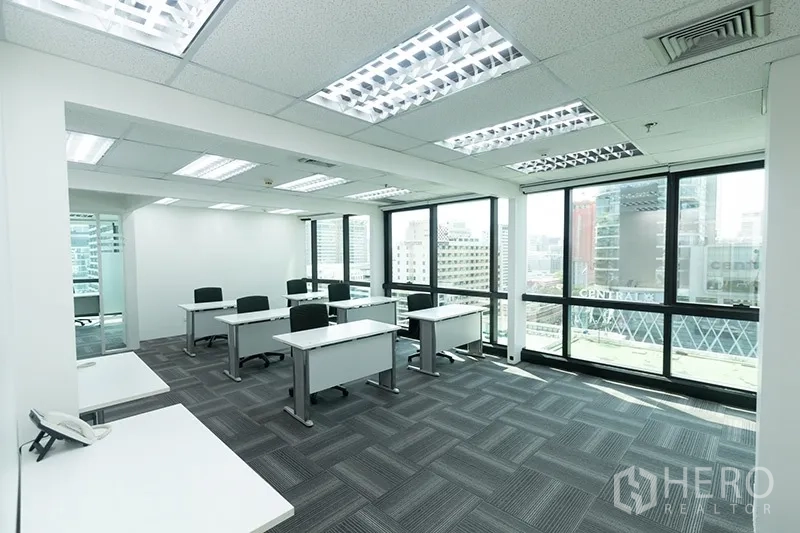 办公空间 出租 - 多工位工作区，地毯地面与整面落地窗，视野开阔。