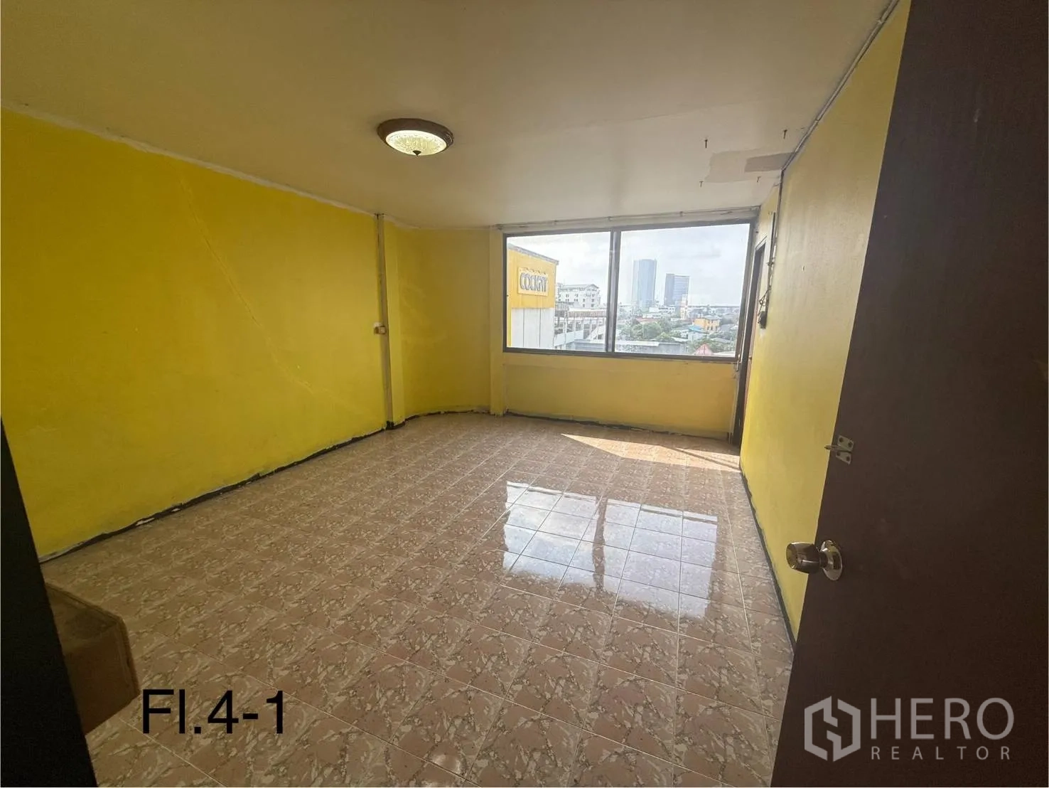 Shophouse for rent in Bang Na, Bangkok - Fourth-floor room with yellow walls, large window, and skyline views.