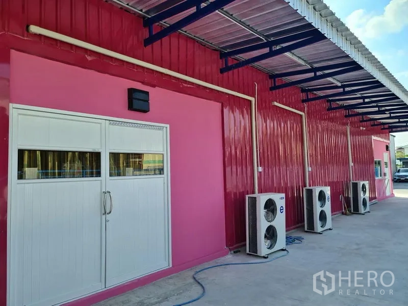 Warehouse for rent in Khlong Luang, Pathum Thani - Front elevation with covered walkway and multiple outdoor AC condenser units.