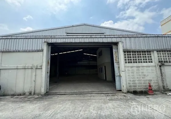 คลังสินค้า ให้เช่าในWatthana, Bangkok - ด้านหน้าโกดังผนังเมทัลชีท ประตูบานเลื่อนขนาดใหญ่ ใต้ท้องฟ้าสดใส