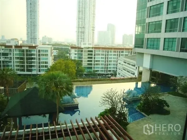 Condominium for rent in Khlong San, Bangkok - Elevated view of landscaped pool deck and city skyline from a Khlong San condo.