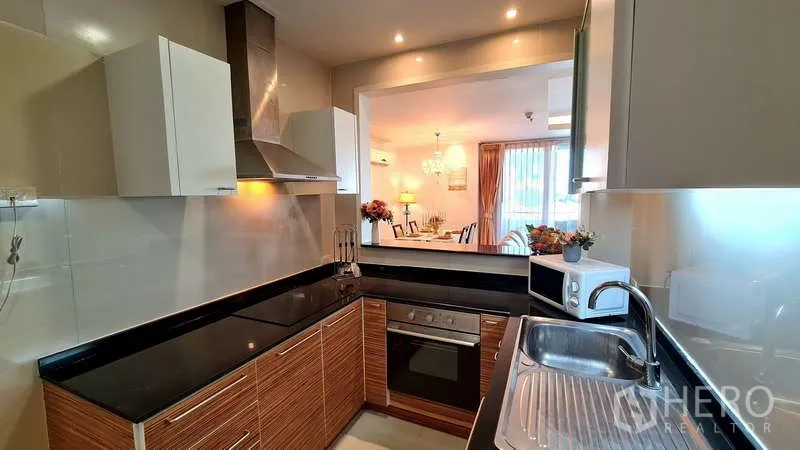 คอนโด ให้เช่าในWatthana, Bangkok - ครัวรูปตัวยูทันสมัย เตาอบ เครื่องดูดควัน และช่องเสิร์ฟเชื่อมกับห้องอาหาร