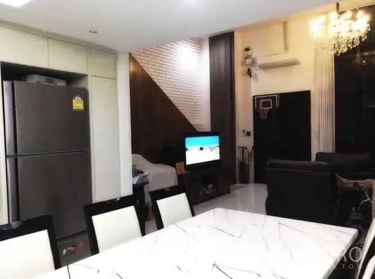 Townhouse for rent in Bang Rak, Bangkok - Open-plan space showing dining table, sleek kitchen, and living room with TV and chandelier.