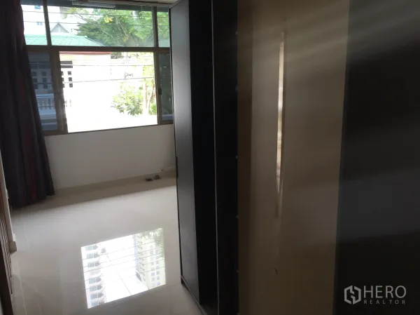 ทาวน์เฮาส์ ให้เช่าในKhlong Toei, Bangkok - ห้องนอนมีหน้าต่างกว้าง พื้นเงา และโครงตู้เสื้อผ้า มุมมองต้นไม้ร่มรื่น