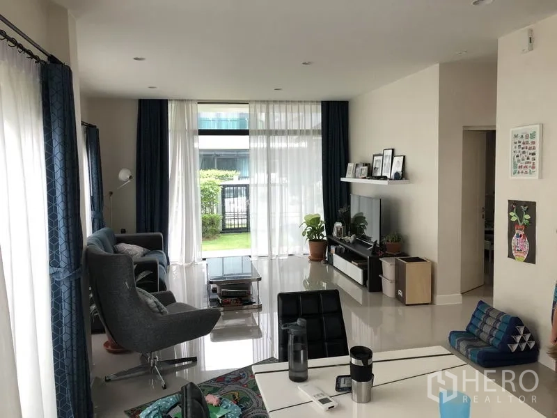 บ้าน ให้เช่าในBang Kapi, Bangkok - ห้องนั่งเล่นสว่างด้วยกระจกบานใหญ่ มองเห็นสวนและชั้นวางทีวี