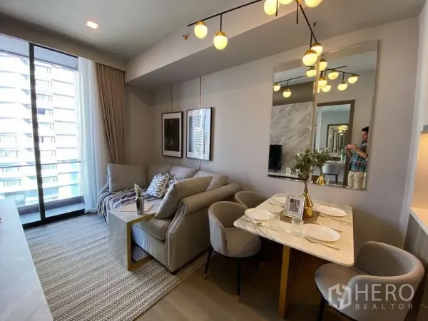 คอนโด ให้เช่าในWatthana, Bangkok - ห้องนั่งเล่นและรับประทานอาหารสว่าง โซฟา โต๊ะหินอ่อน โคมไฟแขวน และระเบียงชมวิวเมืองในคอนโดสมัยใหม่