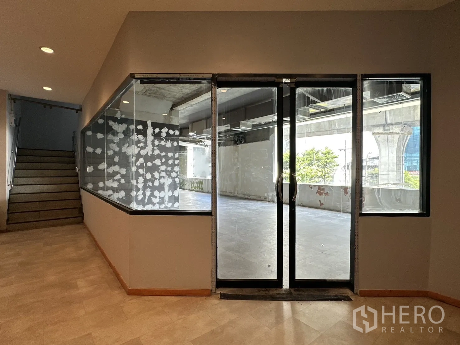 Retail Space for rent in Watthana, Bangkok - Entrance to the unit with double glass doors beside a stairway and corner glazing.