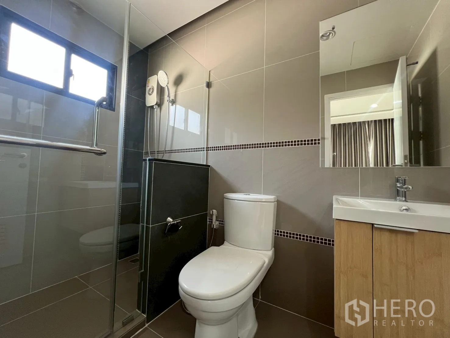 Detached House for rent or sale in Bang Phli, Samut Prakan - Second bathroom with sliding-glass shower, toilet and compact vanity.