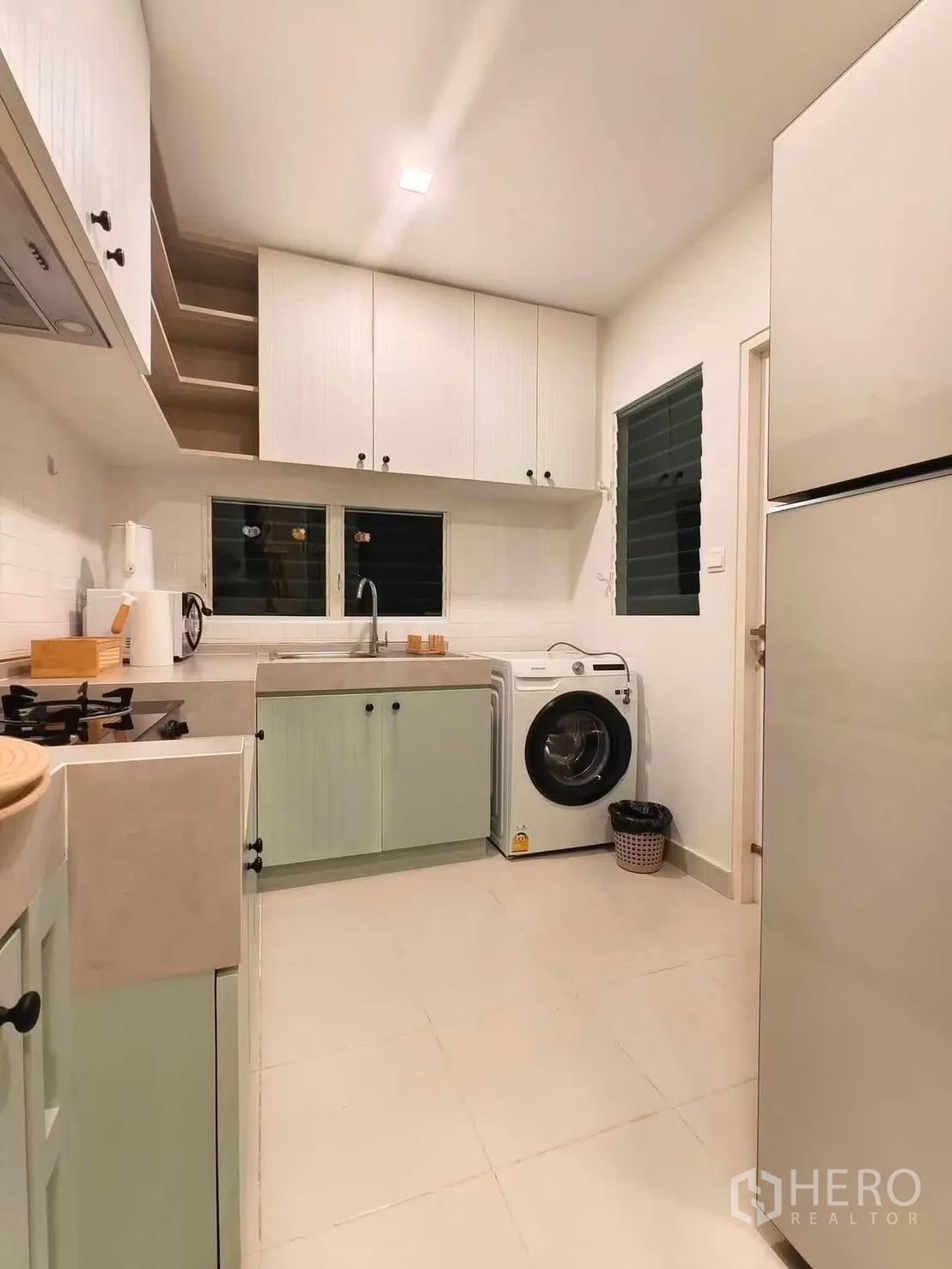 独栋房屋 for rent in Bang Phli, Samut Prakan - 明亮厨房设薄荷绿柜体、顶柜与前开式洗衣机。
