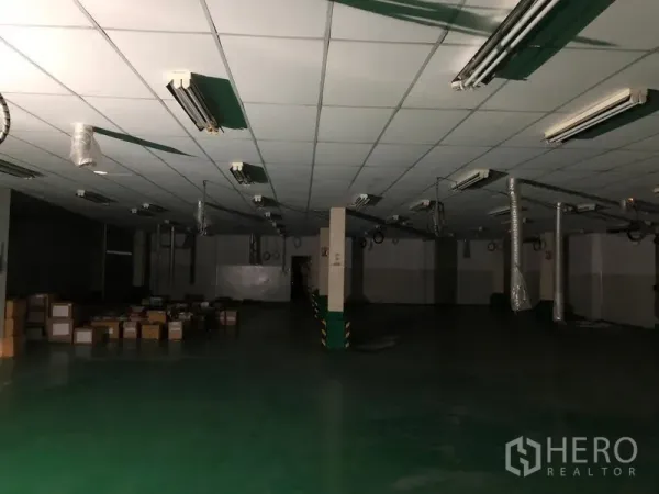 Factory for rent or sale in Khlong Luang, Pathum Thani - Large production floor with suspended ducts, fluorescent light fixtures and wide open layout.