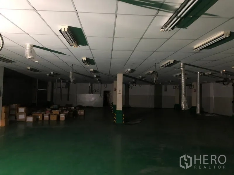 Factory for rent or sale in Khlong Luang, Pathum Thani - Large production floor with suspended ducts, fluorescent light fixtures and wide open layout.