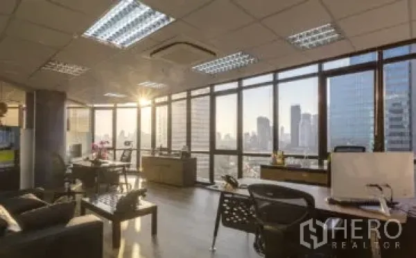 สำนักงาน ให้เช่าในKhlong Toei, Bangkok - ออฟฟิศแบบเปิดโล่ง ผนังกระจกเต็มบาน วิวเมืองยามเย็น พื้นไม้ โต๊ะทำงาน และแอร์ฝ้าเพดาน