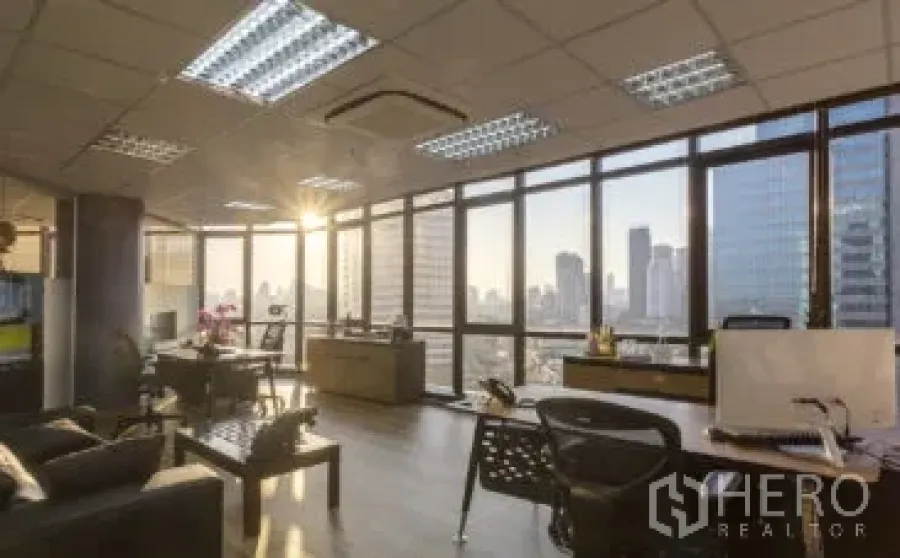 สำนักงาน ให้เช่าในKhlong Toei, Bangkok - ออฟฟิศแบบเปิดโล่ง ผนังกระจกเต็มบาน วิวเมืองยามเย็น พื้นไม้ โต๊ะทำงาน และแอร์ฝ้าเพดาน