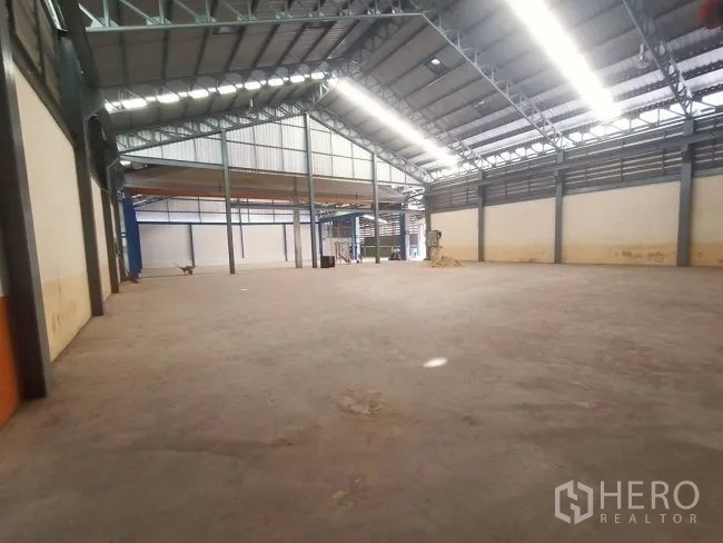 Factory for rent in Mueang Samut Sakhon, Samut Sakhon - Large open warehouse area with a gable roof, ventilation panels, and a polished concrete floor.
