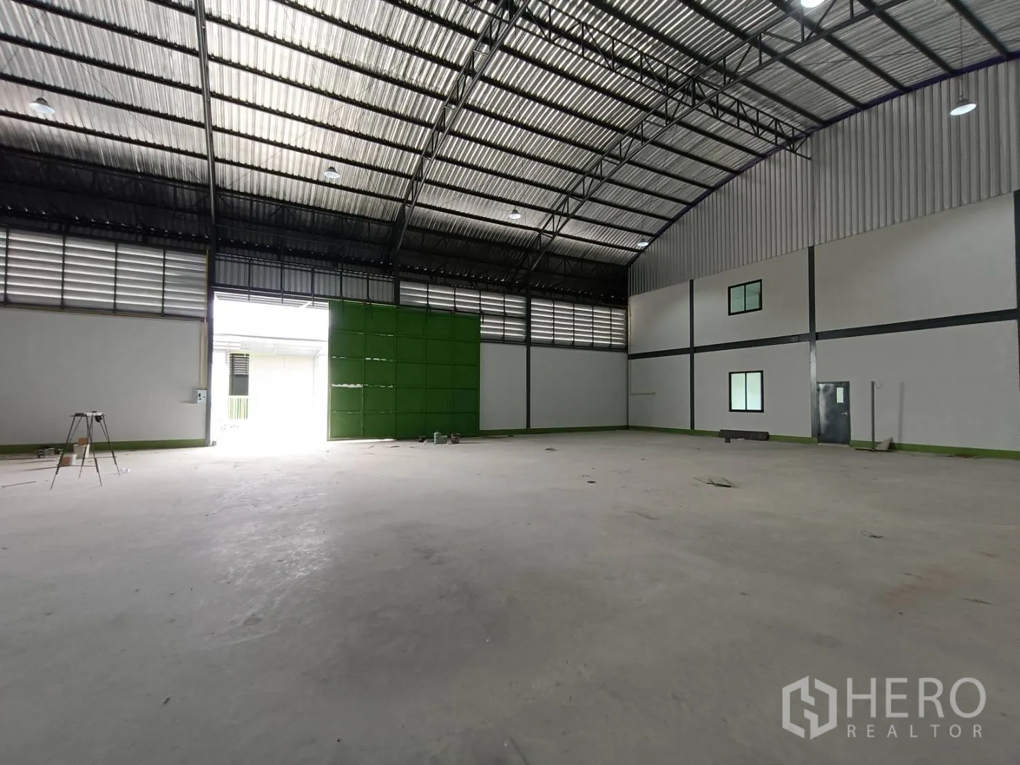 โรงงาน ให้เช่าในLam Luk Ka, Pathum Thani - มุมมองโกดังไปยังประตูขนถ่ายสีเขียว พร้อมหลังคาโค้งและช่องลม