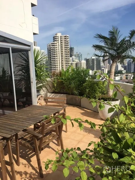 คอนโด ให้เช่าในKhlong Toei, Bangkok - เทอเรซกว้างพร้อมโต๊ะรับประทานอาหารกลางแจ้ง ต้นไม้เมืองร้อน และวิวเมืองพาโนรามา
