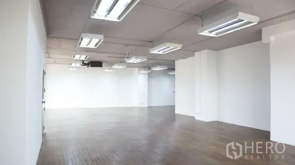 สำนักงาน ให้เช่า - โถงสำนักงานยาว พื้นไม้ โคมไฟแถบ และผนังสีขาวเรียบ