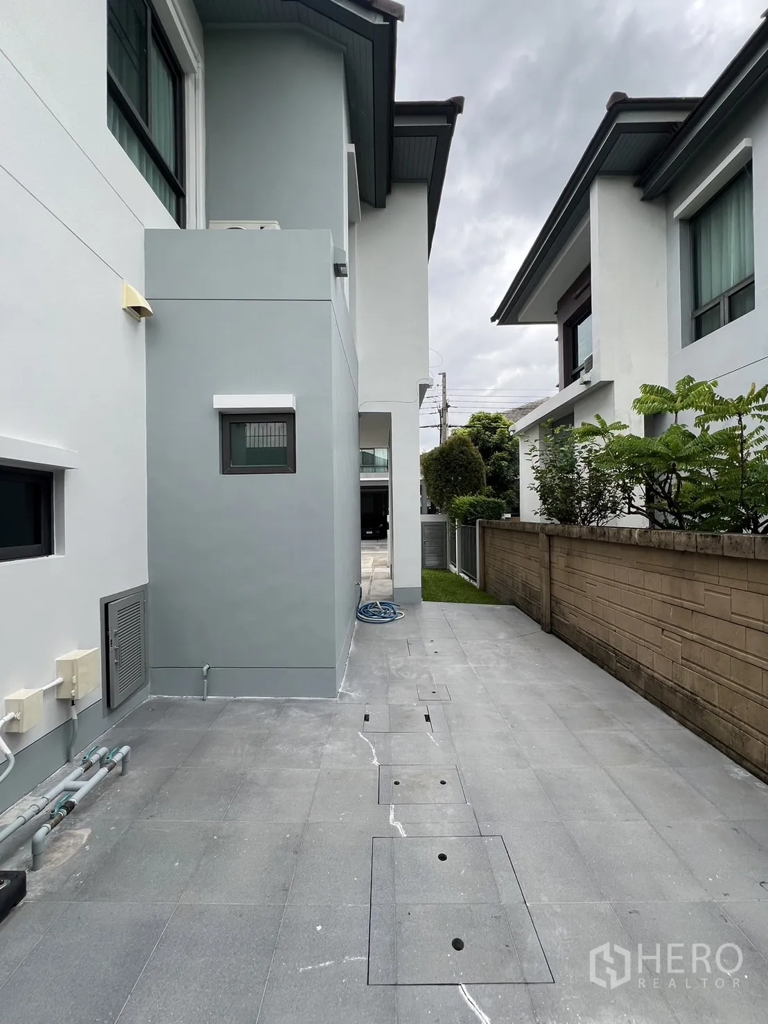 独立式住宅 出租在Bang Kapi, Bangkok - 房侧家务庭院，铺砖步道与外露管线。