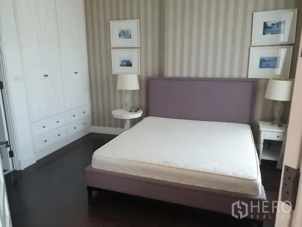 คอนโด ให้เช่าในKhlong Toei, Bangkok - ห้องนอนพร้อมเตียงบุผ้า วอลเปเปอร์ลายทาง และตู้เสื้อผ้าบิลท์อินสีขาว