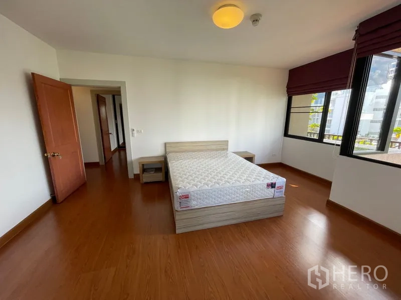 Condominium for rent in Watthana, Bangkok - Third bedroom with large windows, wood floors and natural light.