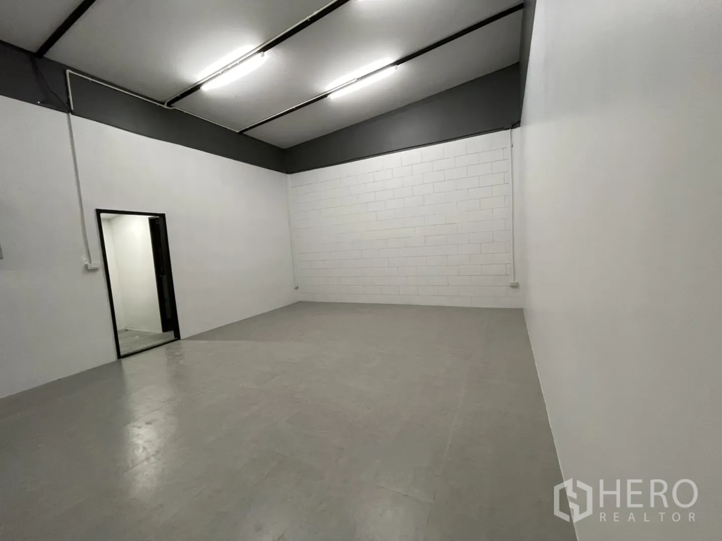 คลังสินค้า ให้เช่าในLam Luk Ka, Pathum Thani - ห้องใช้งานผนังสีขาว พื้นกระเบื้องสีเทา และประตูเชื่อมส่วนบริการ.