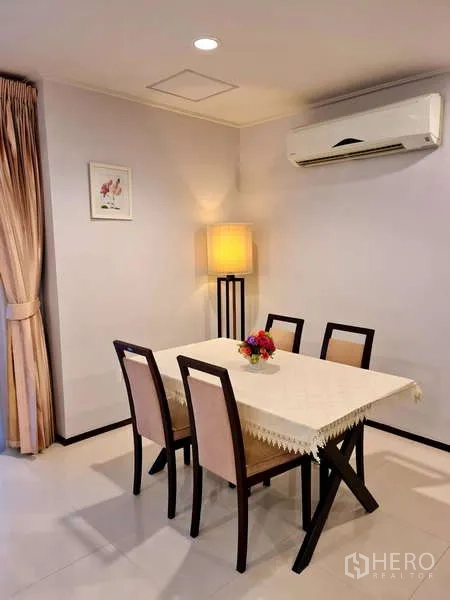 อพาร์ทเมนท์ ให้เช่า - มุมรับประทานอาหารสี่ที่นั่ง โต๊ะผ้าปู เก้าอี้บุนวม และโคมไฟตั้งพื้น