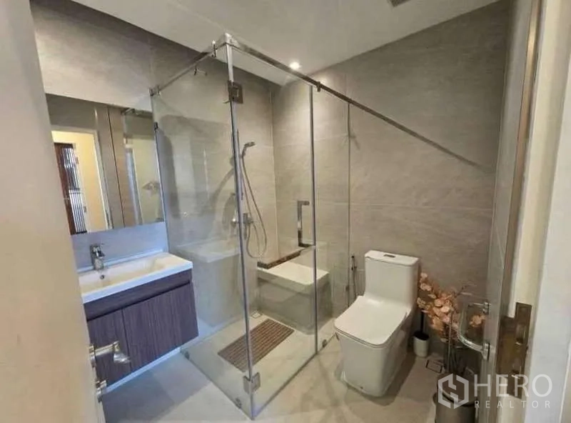 Townhouse for rent - Modern bathroom with a glass-enclosed shower, vanity, and toilet in neutral tones.