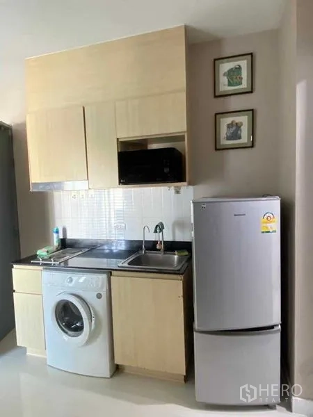 Condominium for rent in Phra Khanong, Bangkok - Compact kitchenette with refrigerator, sink, microwave and washing machine.