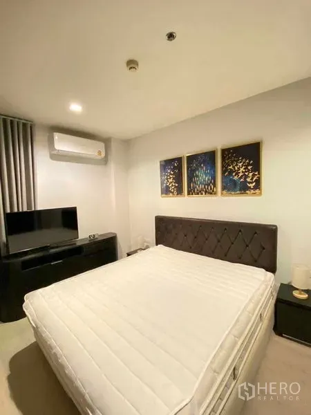 คอนโด ให้เช่าในKhlong Toei, Bangkok - ห้องนอนหลักสไตล์อบอุ่น หัวเตียงบุ ตกแต่งภาพ แขวนทีวีและเครื่องปรับอากาศ คอนโดย่านพระโขนง