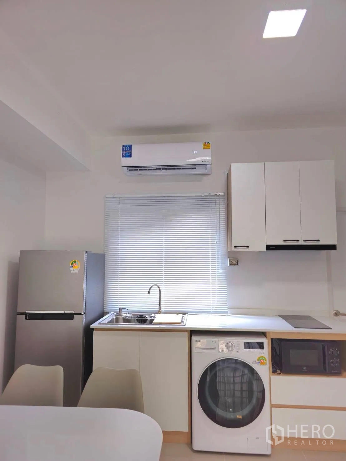 Townhouse for rent in Bang Phli, Samut Prakan - Compact kitchen with sink, cooktop, microwave, refrigerator and washer.