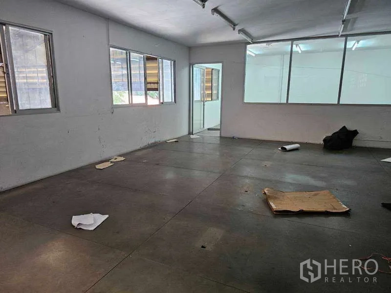 Warehouse for rent or sale in Khlong Toei, Bangkok - Upper-level office space with multiple windows and a glass partition, ready for fit-out.