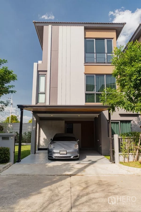 บ้าน ให้เช่าหรือขายในPrawet, Bangkok - ด้านหน้าบ้านโมเดิร์นสูง 3 ชั้น มีที่จอดรถในร่มและทางเข้า พร้อมสนามหญ้ามุมบ้าน