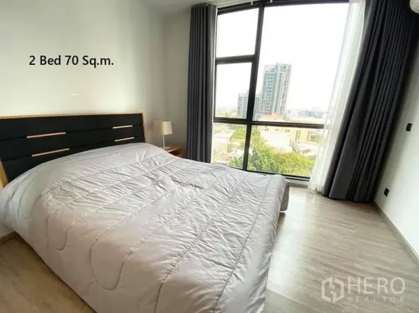 Condominium for rent in Watthana, Bangkok - Bright bedroom with floor-to-ceiling windows and city view in a 2-bed 70 sqm condo near BTS Ekkamai.